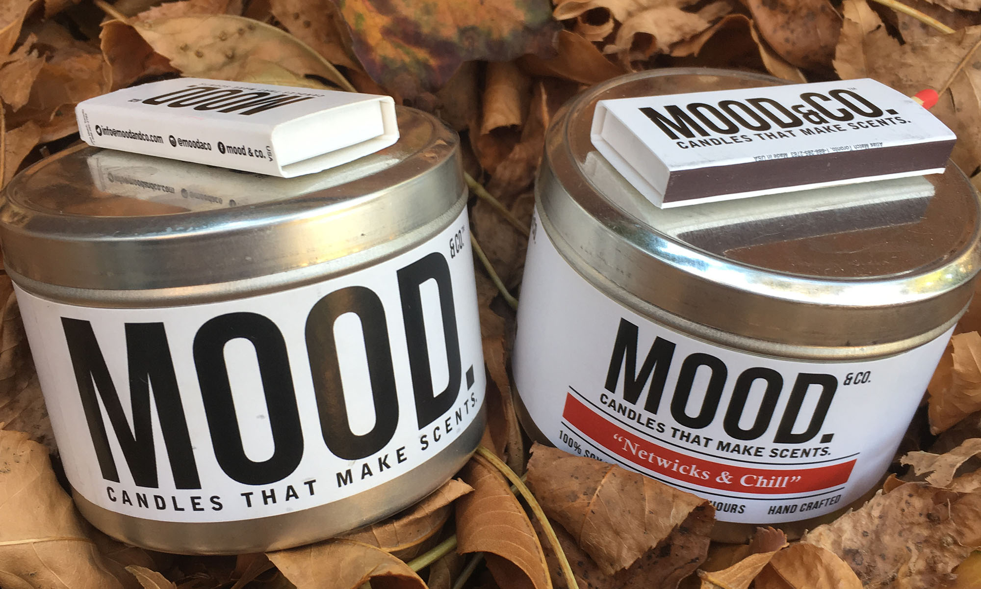 A photo of candles in dry leaves.